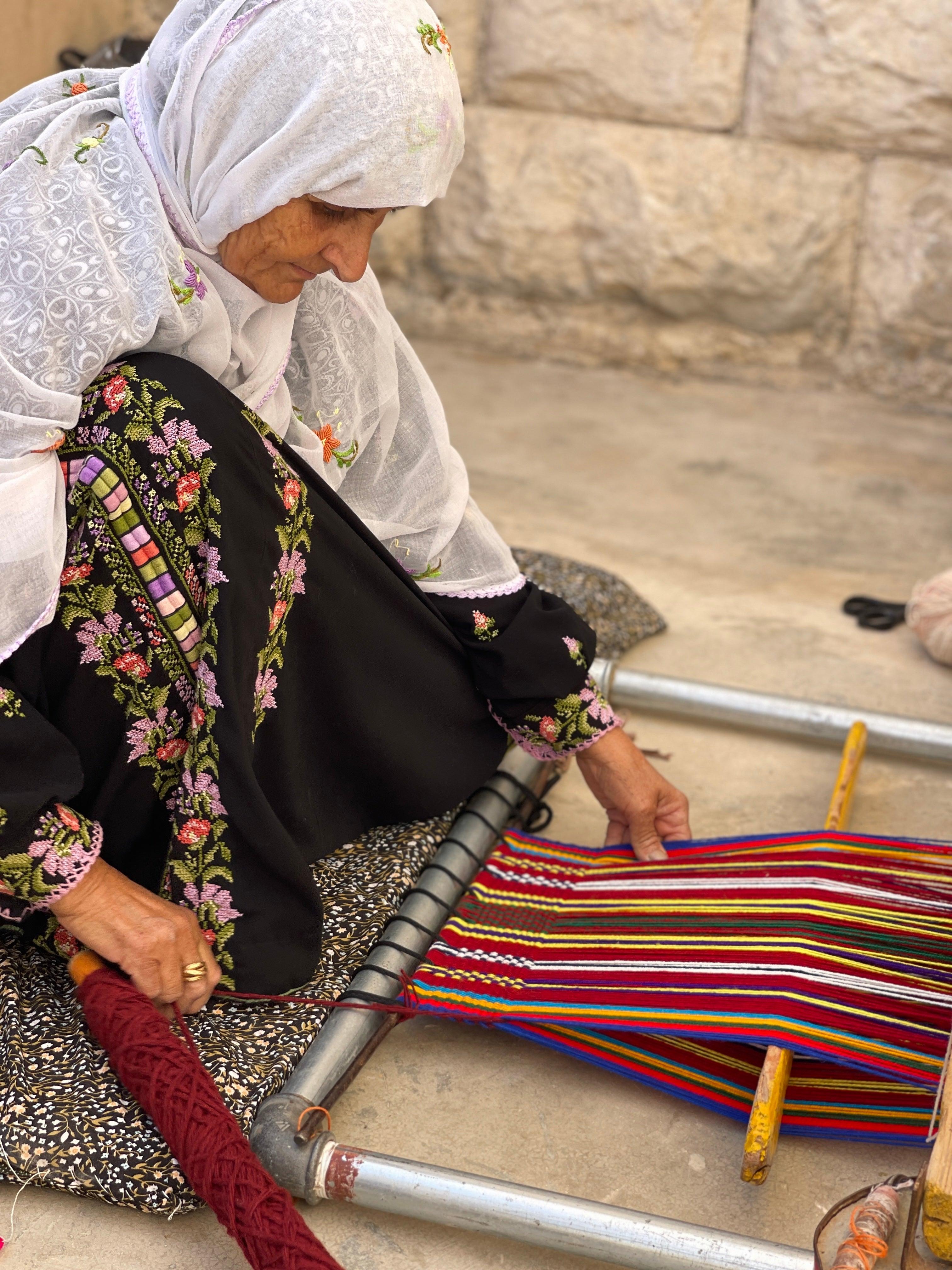 حرفية فلسطينية تنسج على نول يدوي تقليدي